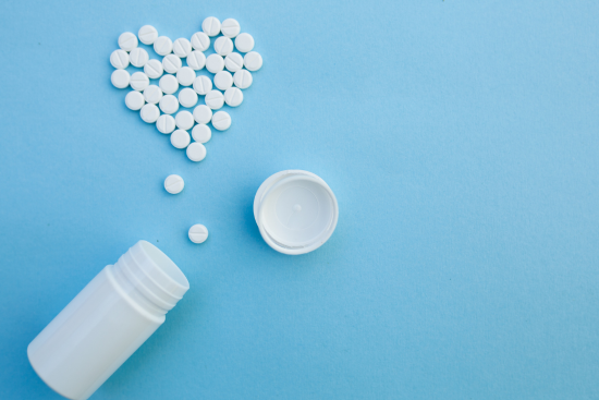 bottle with pills laid out in heart shape